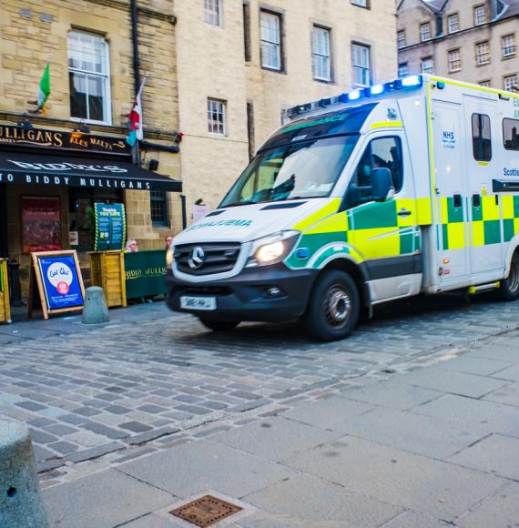 Emergency Ambulance driving through Grassmarket in Edinburgh