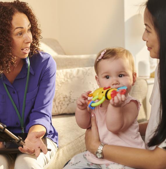 Official chatting to young mother