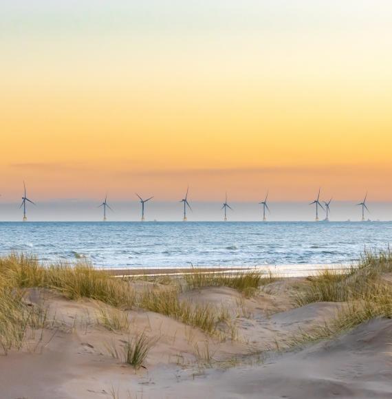 Offshore windfarm with sand dunes in the foreground