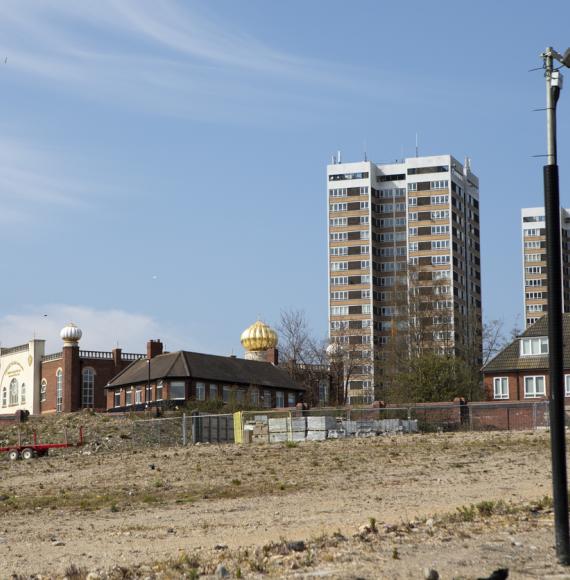 housing against a clear sky with barren land ready for development in the foregound