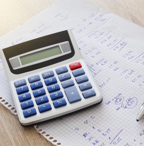 Calculator, paper with numbers and pen