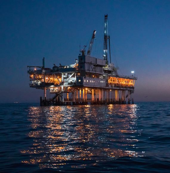 Night Time Offshore Oil Rig Drilling and Fracking Operation, Brightly Lit, on Calm Seas, Oil Platform