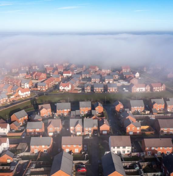 New estate with typical British houses and green gardens hidden by clouds