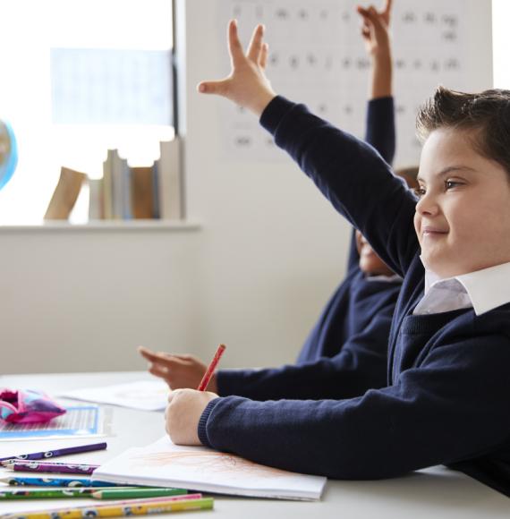 Schoolboy with Down syndrome sitting at a desk