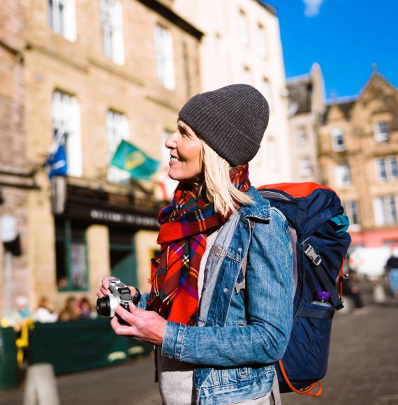 Tourist photographing at the Grassmarket, Edinburgh, Scotland.