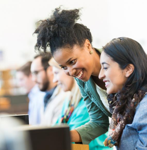 Diverse mid adult students using computers during class in college