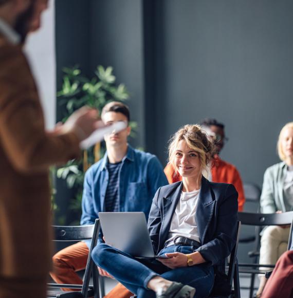 Group of men and women sitting and listening to a seminar.