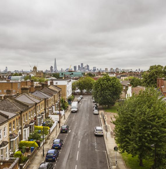 Peckham street with residential housing and the city skyline with skyscrapers on the horizon.