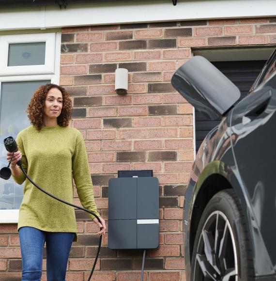 homeowner charging electric car on driveway