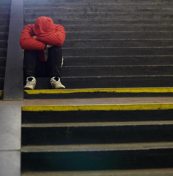 young homeless man sleeping on the street