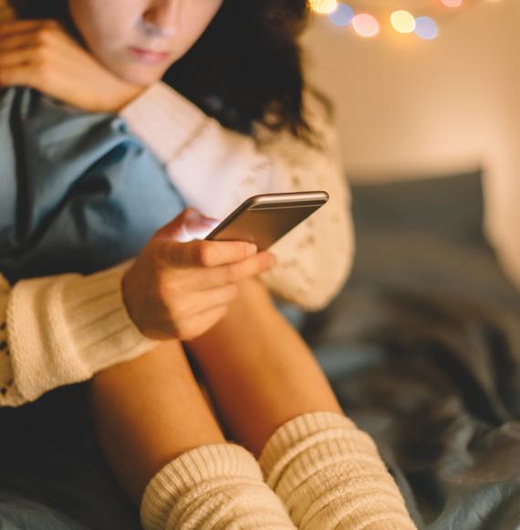 Girl texting on smartphone at home