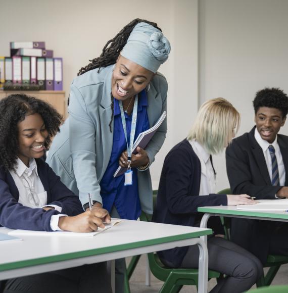 Multiracial group of teenagers in uniforms sitting together at desks