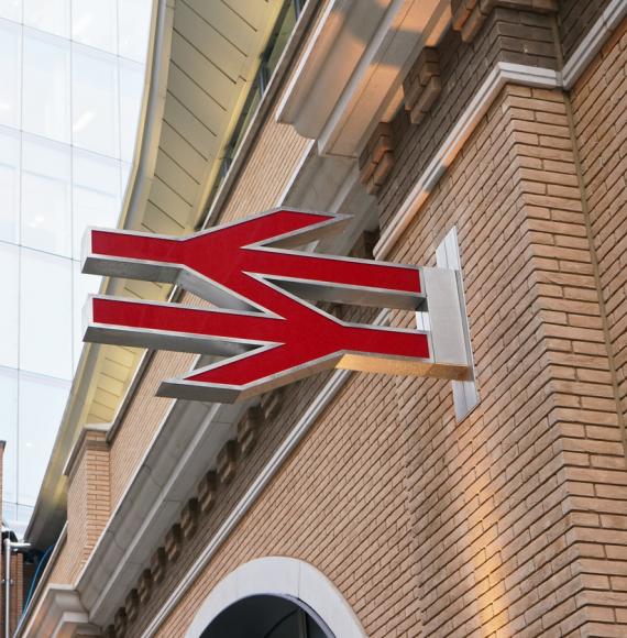 Red British railway logo on orange brick wall