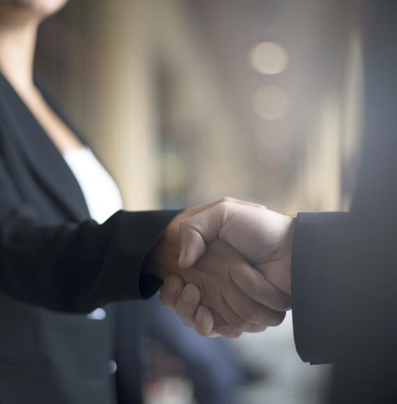 Two people shaking hands on business event.