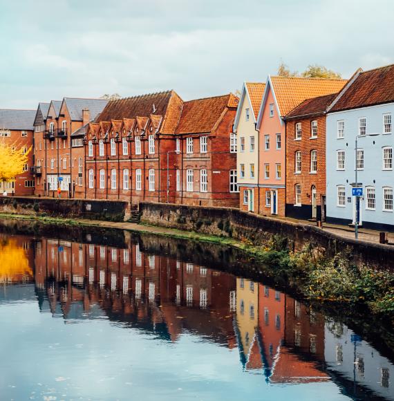 Street view with colorful brick houses near river in the english town of Norwich, England