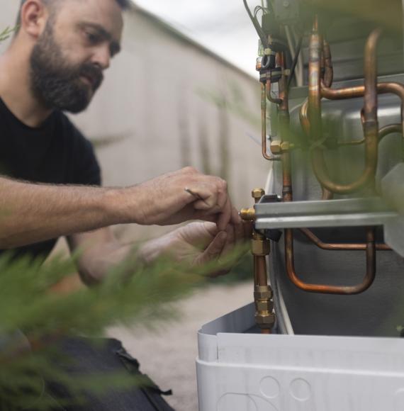 Technician installing a heat pump in the yard