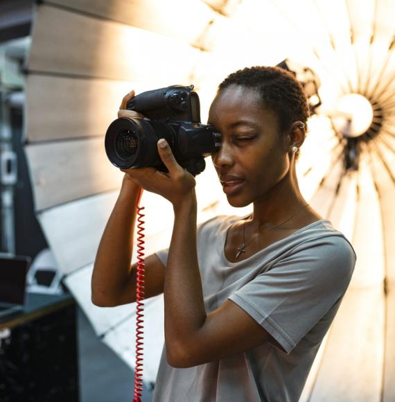 Young photographer standing in front of a reflective umbrella