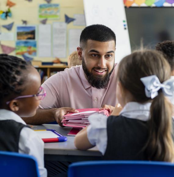 A teacher working with two primary school students