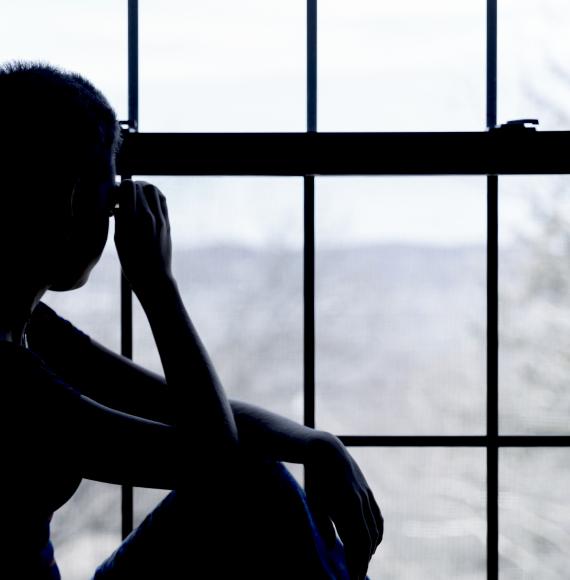 Teenage girl looking out of a hostel window