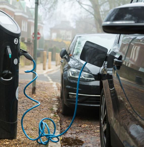 A modern electric car being charged at a charging point