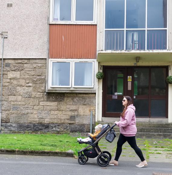 Mother and baby walking through a council estate