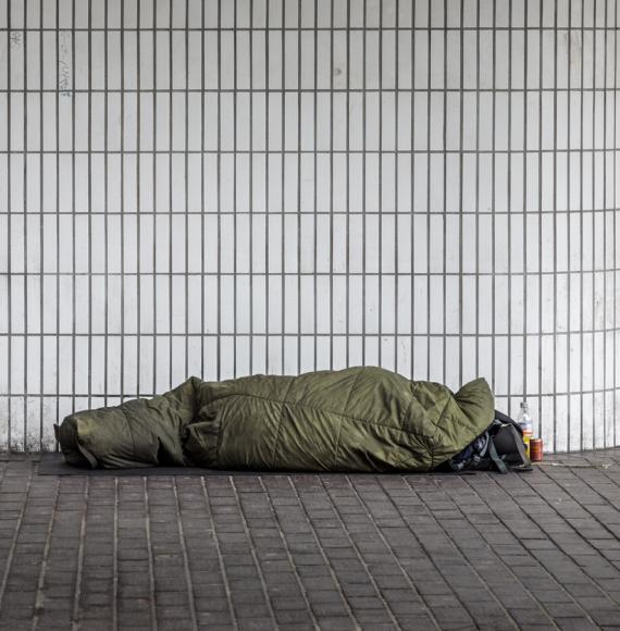 A homeless man in a sleeping bag outside Euston Station, London