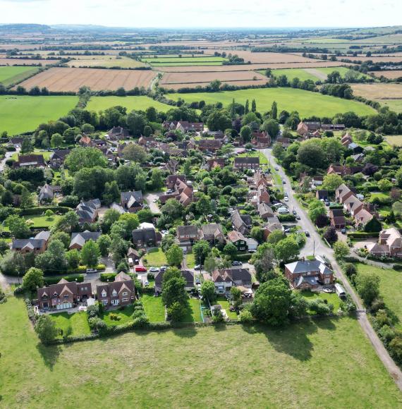 A row of quaint and colourful houses in a lush green field