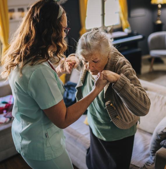 A nurse visits an elderly disabled woman at home