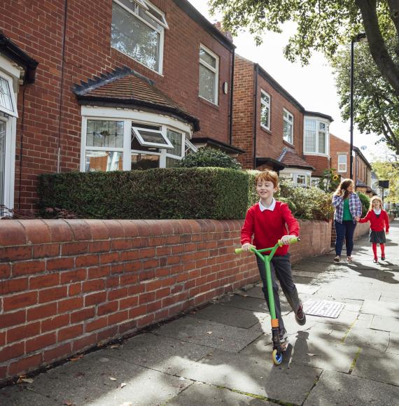 Manchester child using a scooter to get to school