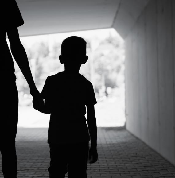 Poor child walking with single parent