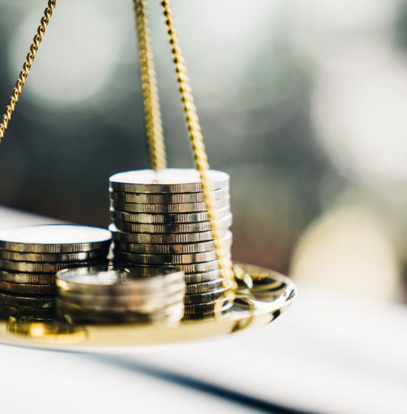 Stack of coins balancing on a scale