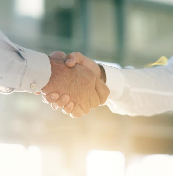 Two men shake hands on an office