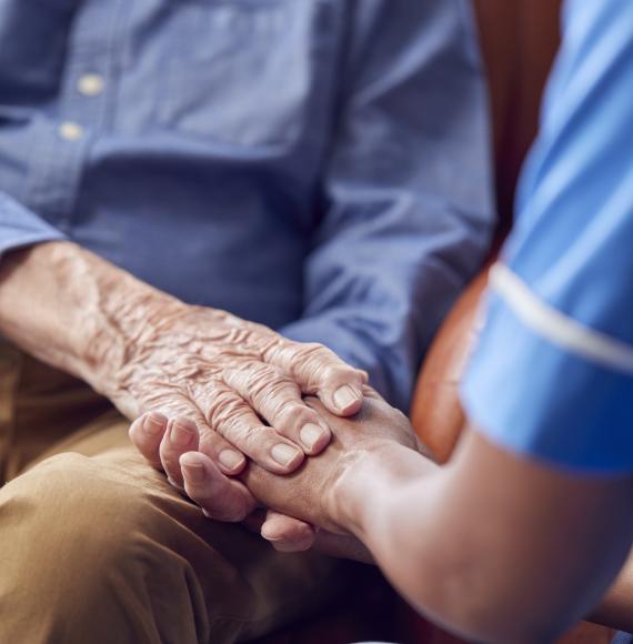 Nurse holding mans hand