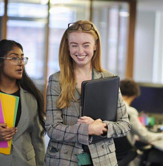 Two interns walking through an office