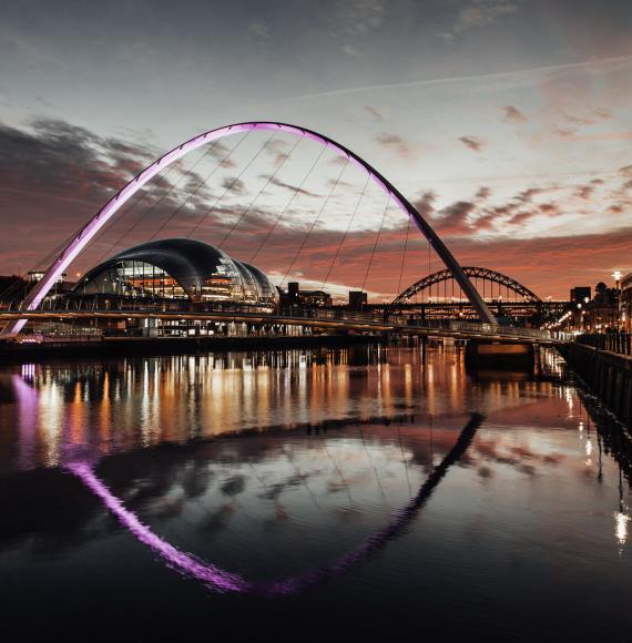 Millennium bridge at sunset with the Tyne Bridge in the background