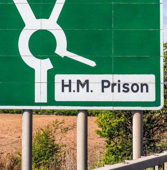 Prison sign next to a road